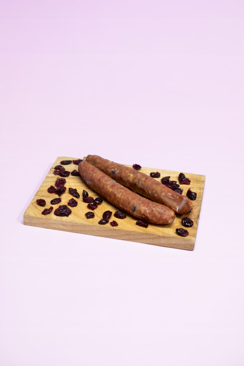Cranberry worst van slagerij Schaafsma, Onze alom bekende droge worst met een van de bekendste producten van het eiland: de cranberry. Gerookt met beukensnippers. Tip van de slager: snijd de worst schuin aan voor een breder smaakoppervlak. 2 stuks per verpakking